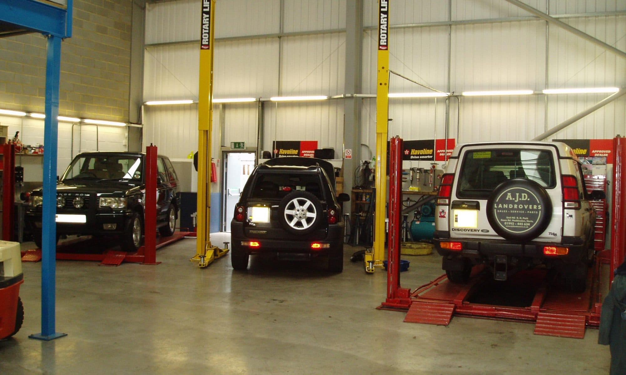Multiple vehicles positioned on two-post hoists inside the Apex DIY facility